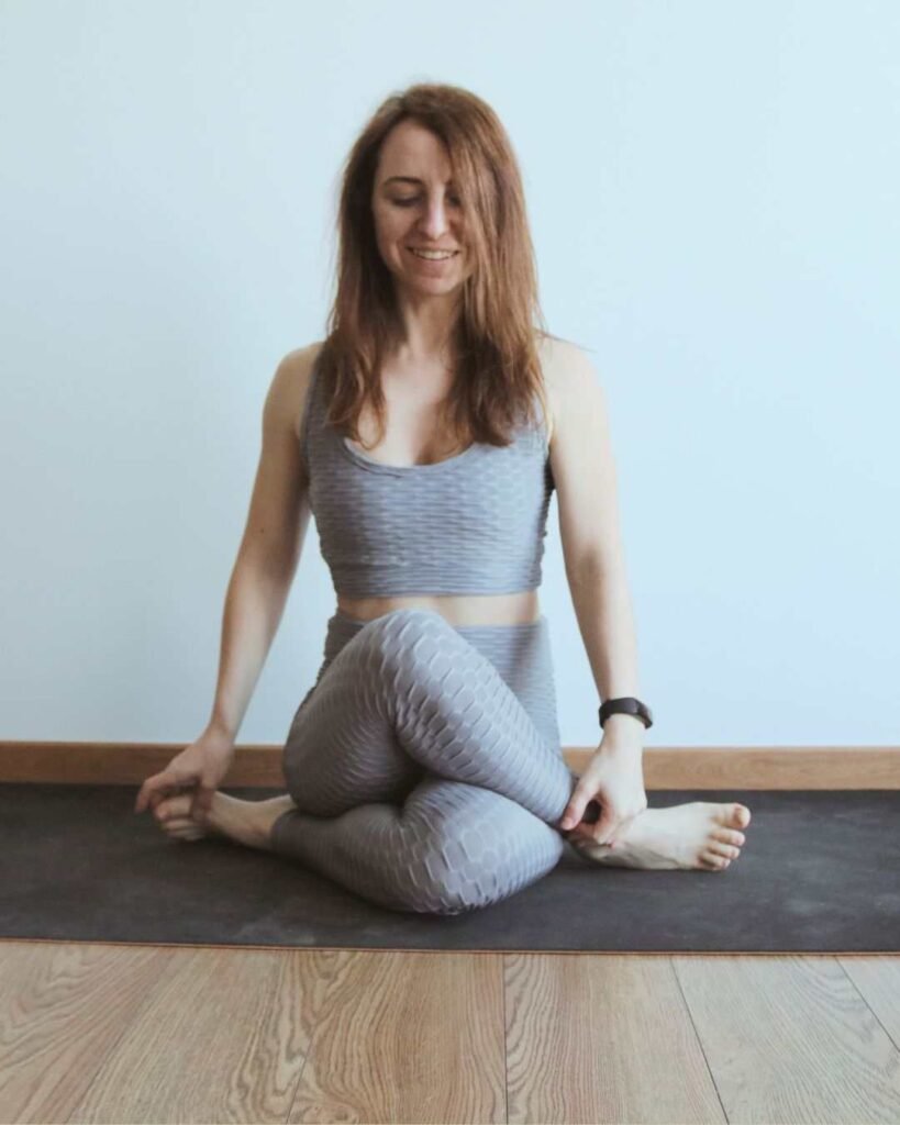 Woman practicing yoga hip opening pose on mat – mindful movement, flexibility and wellness routine