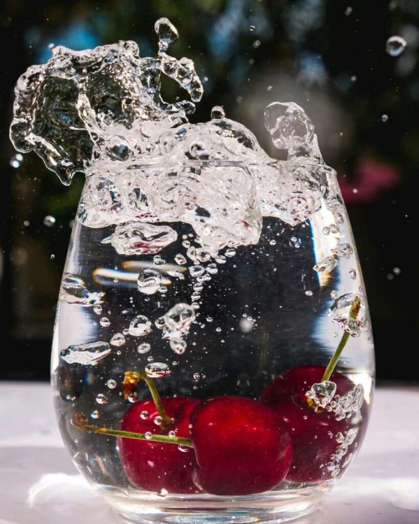 Splash of berry infused water in glass – refreshing natural hydration